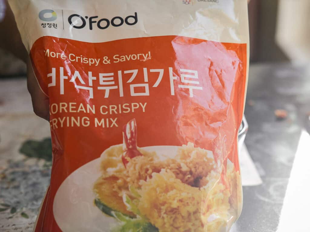 A bag of OFood Korean Crispy Frying Mix with red and white packaging. The front features an image of fried shrimp and vegetables. Text on the bag highlights More Crispy & Savory!.